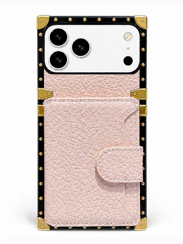 A luxury-style phone case with a light pink textured leather front pocket, a black border, gold-tone metal studs, and corner protectors, shown on a white phone against a clean white background.