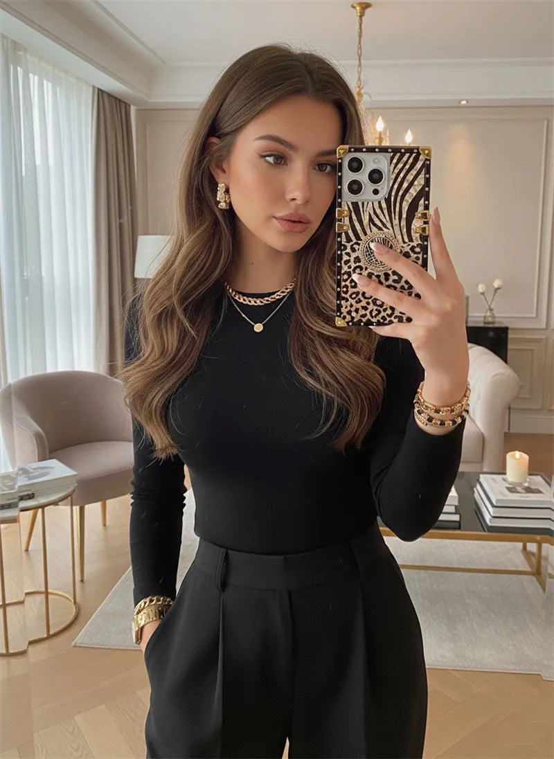 Woman taking a mirror selfie in a stylish room with leopard phone case