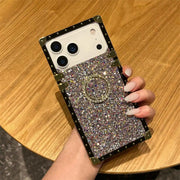Phone case with silver glittery design held by a hand on a wooden surface