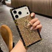 Hand holding a gold glittery phone case with a blurred indoor background