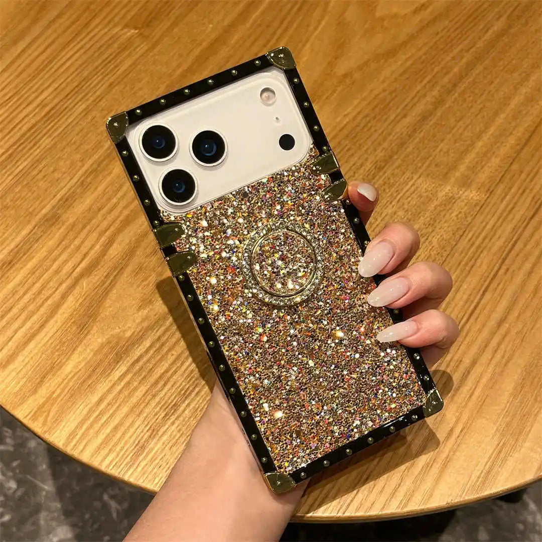 Phone case with glittery design held by a hand on a wooden surface