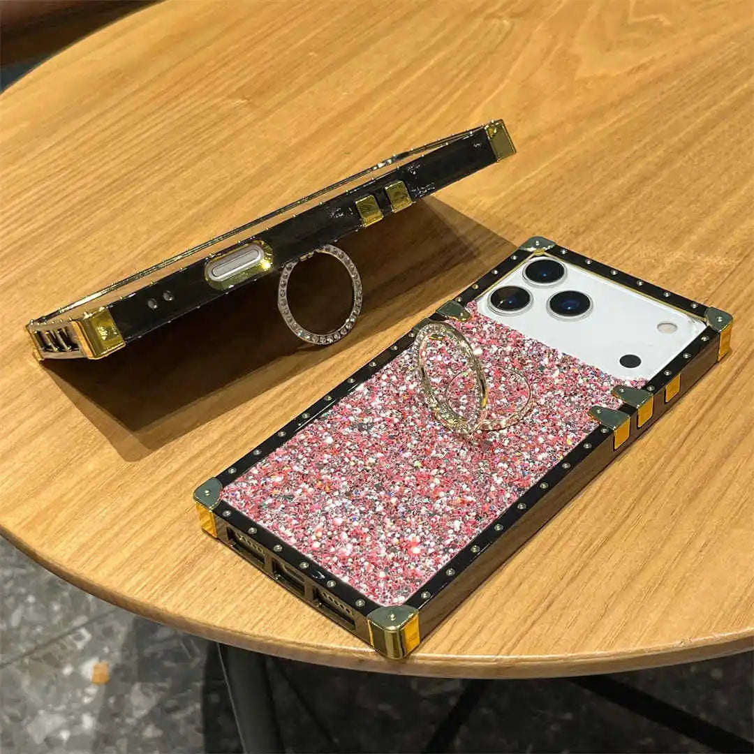 Phone case with glittery design and ring holder on a wooden surface