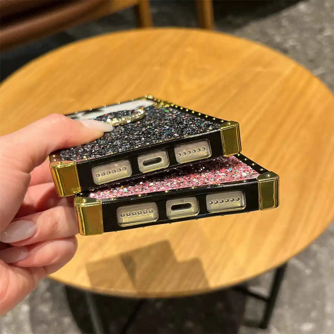 Hand holding a glittery phone case on a wooden table