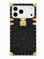 A luxury-style smartphone case featuring a black glittery textured body with gold-tone metal trim, corner protectors, and a central clasp, shown on a white phone against a light gray background.