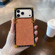 Phone case with grid pattern held by a hand on a table with a cup in the background