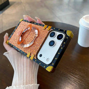 orange MODA Phone case with ring stand held by a hand on a wooden surface