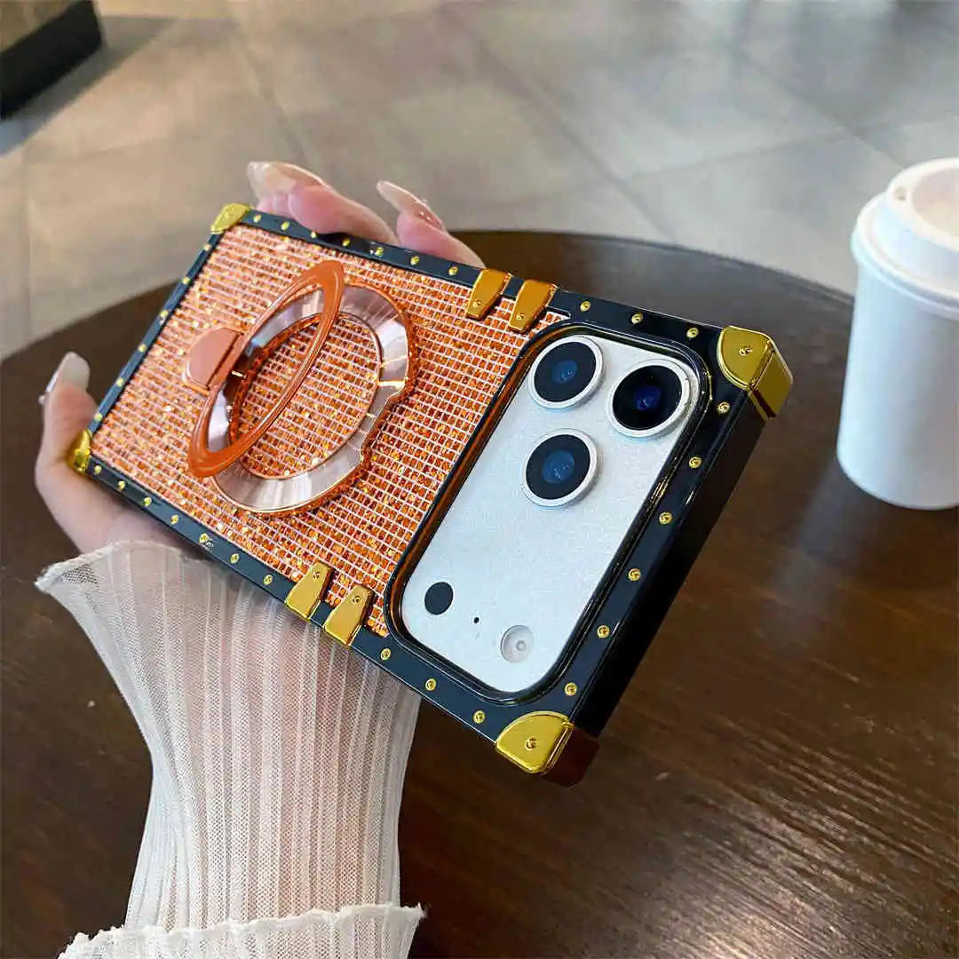 orange MODA Phone case with ring stand held by a hand on a wooden surface