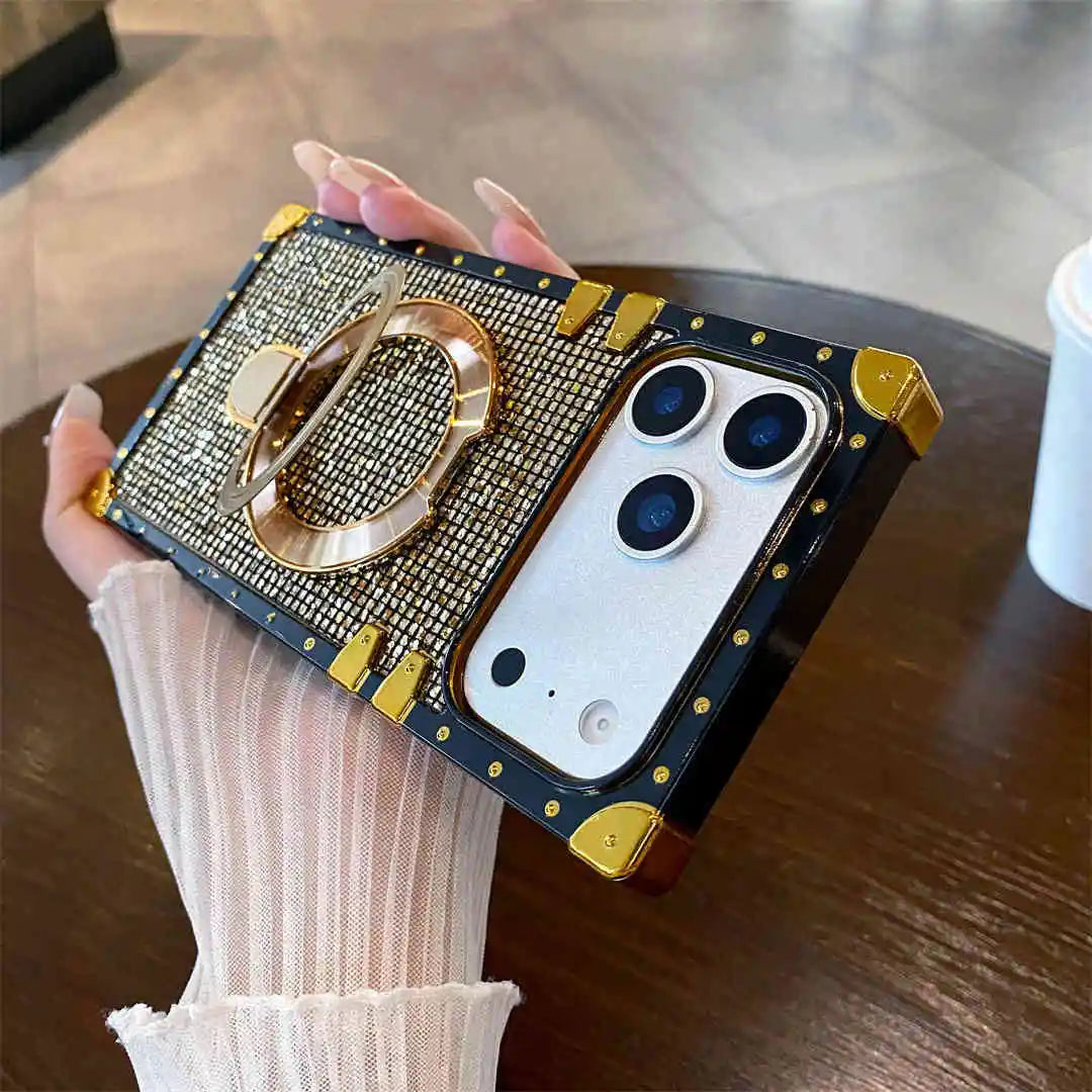 Gold bling Phone case with decorative ring holder held by a person on a wooden surface.