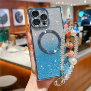 Phone case with glittery design and pearl strap held by a person in an indoor setting.