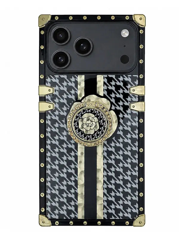 A luxury-style phone case designed for an iPhone 17 Pro, featuring a black and white houndstooth pattern, vertical cream stripes, gold-tone hardware, and a central rose medallion on a white background.