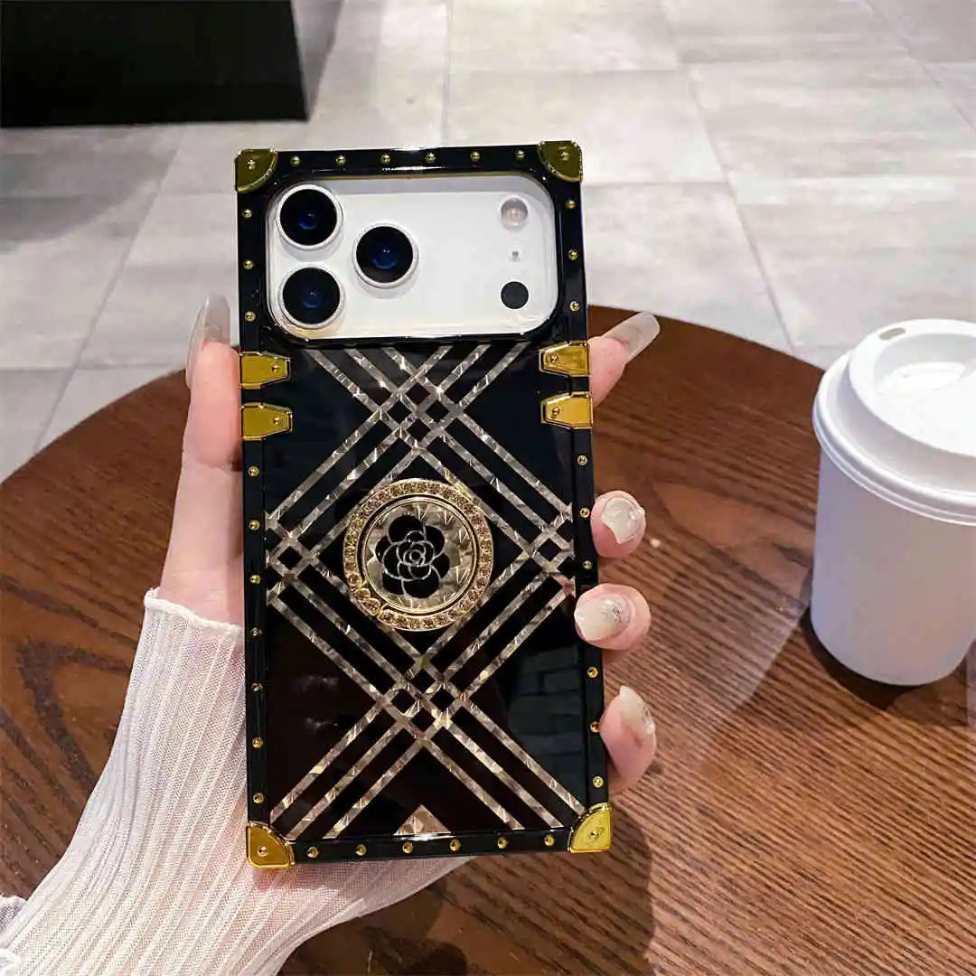 Phone case with geometric design held by a hand on a wooden table.