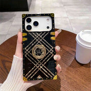 Phone case with geometric design held by a hand on a wooden table.