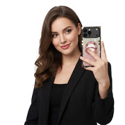 Woman holding a phone with a glittery case against a white background