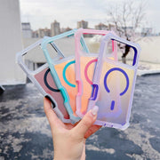 Four transparent phone cases with colorful designs held by a hand outdoors.