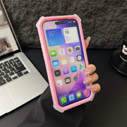 Person holding a phone with a pink case on a desk with a laptop and mug in the background
