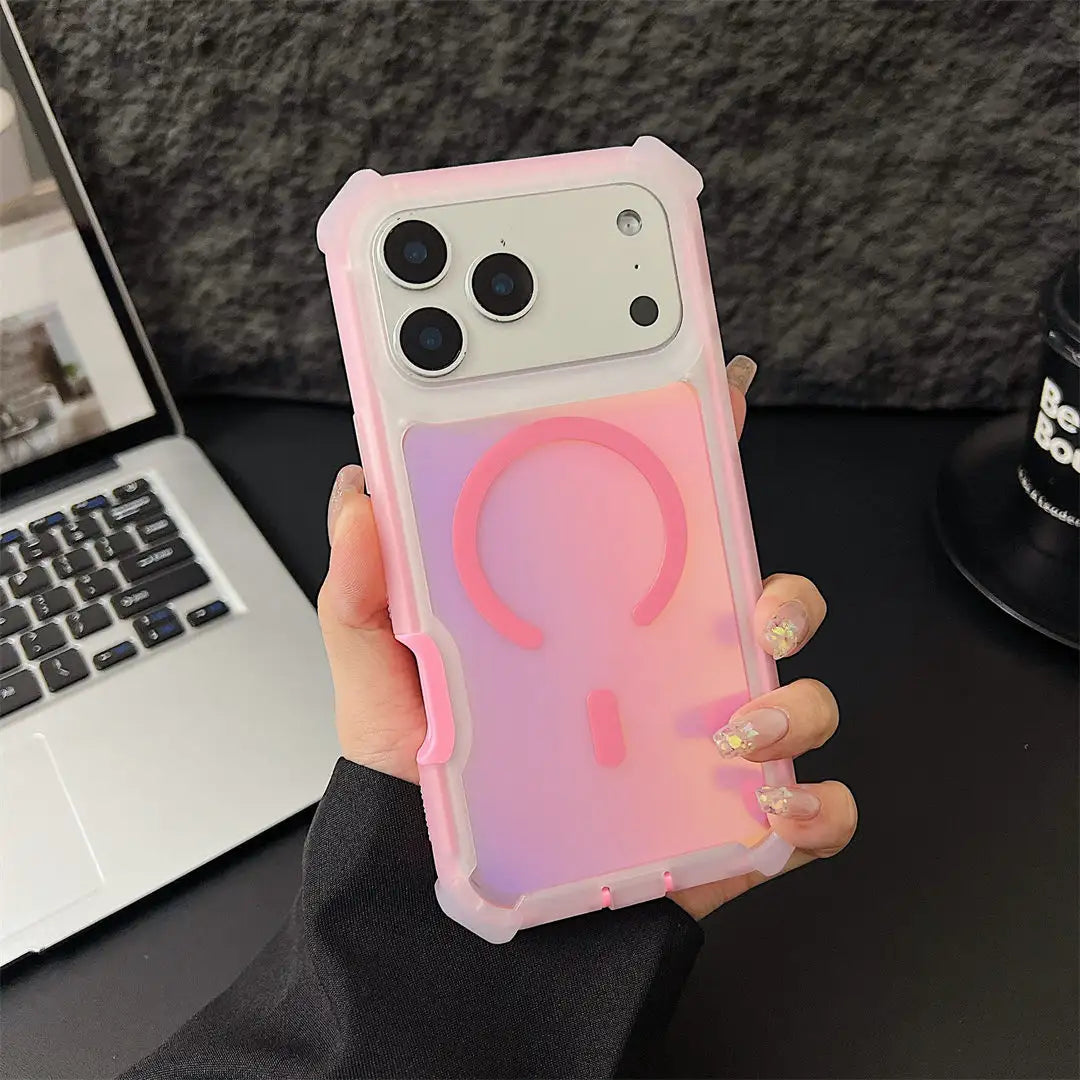 Person holding a phone with a pink and purple gradient case on a desk with a laptop and mug.
