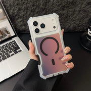 Person holding a phone with a reflective case in front of a laptop and coffee cup.