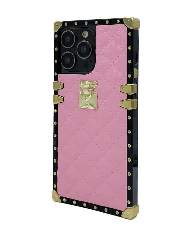 A pink quilted faux-leather phone case designed with a luxury trunk aesthetic, featuring a black border, gold-tone rivets, corner protectors, and a central gold clasp lock, shown on a white background.
