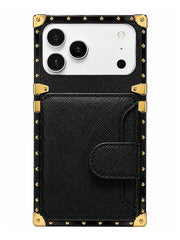 A black textured phone case with gold-tone metal corner protectors and studs, featuring a large front card pocket and a white camera cutout, shown on a plain white background.