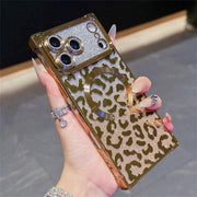 Hand holding a square-shaped phone case with a leopard print design and gold glittery accents.