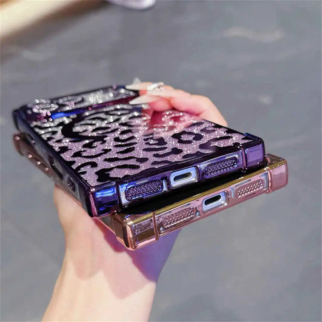 Hand holding a purple phone case with leopard print design on a gray surface
