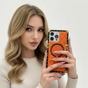 Woman holding an orange phone case with decorative elements
