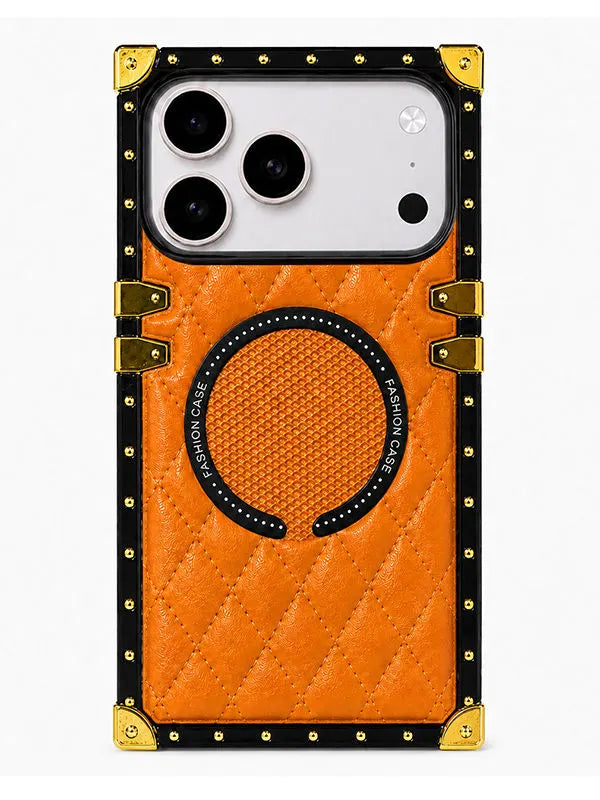 An orange quilted phone case with a black and gold metal-train style border, gold corner protectors, and a circular magnetic ring on the back, shown on a white background.