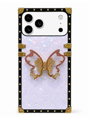A protective phone case with a black border studded with gold rivets, featuring a central iridescent white panel and a 3D gold and pink rhinestone butterfly design.