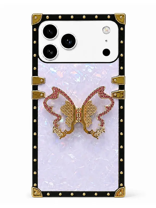 A protective phone case with a black border studded with gold rivets, featuring a central iridescent white panel and a 3D gold and pink rhinestone butterfly design.