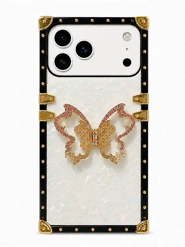 A luxury phone case featuring a white iridescent mother-of-pearl back, a black studded border with gold corner accents, and a central gold and pink rhinestone butterfly embellishment.
