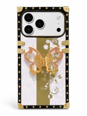 A luxury-style phone case featuring a black frame with gold-tone rivets and corner protectors, a vertical gold stripe on a white iridescent background, delicate gold floral patterns, and a prominent 3D gold butterfly ornament in the center.