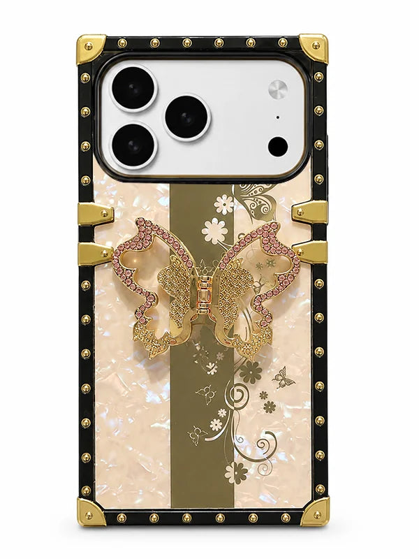 A luxury-style phone case featuring a black border with gold studs, a central beige and olive-green vertical stripe, a large gold butterfly embellished with pink rhinestones, and delicate floral patterns.