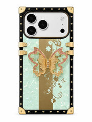 A luxury-style phone case with a black and gold riveted frame, featuring a central design of a gold butterfly over a vertical gold stripe on a light mint green background with white floral details.