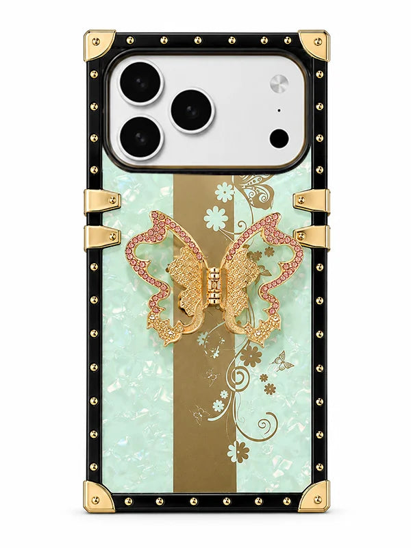 A luxury-style phone case with a black and gold riveted frame, featuring a central design of a gold butterfly over a vertical gold stripe on a light mint green background with white floral details.