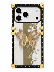 A luxury-style phone case featuring a black border with gold studs and corner protectors, a central gold and white floral panel, and a 3D gold butterfly embellished with pink rhinestones on the back.