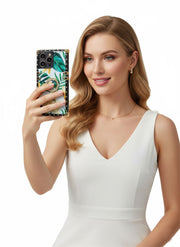 Woman in a white dress holding a phone with a floral case on a white background