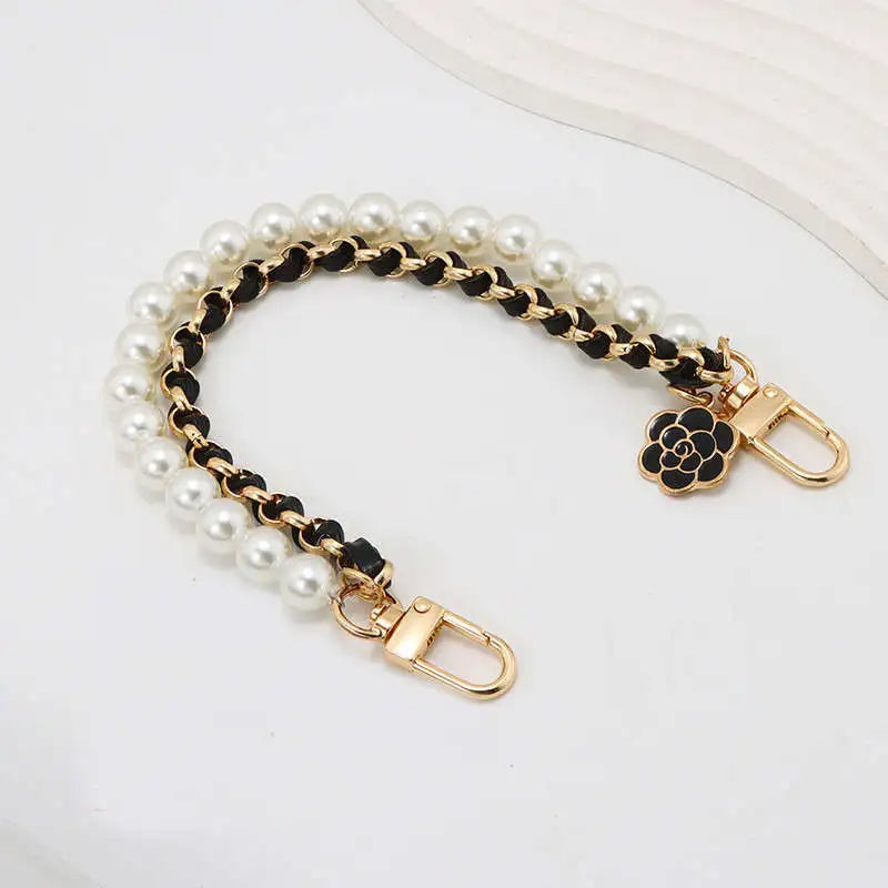 Pearl and chain handbag strap with a gold clasp on a white background