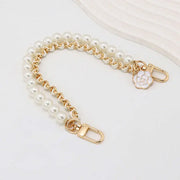 Pearl bracelet with gold chain and clasp on a white background
