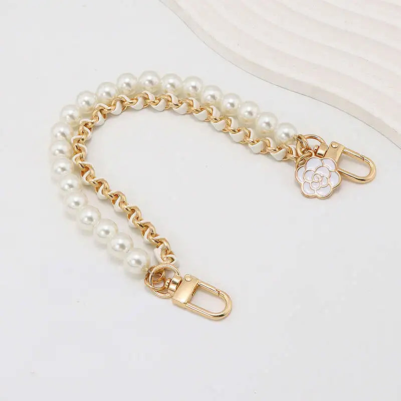 Pearl bracelet with gold chain and clasp on a white background