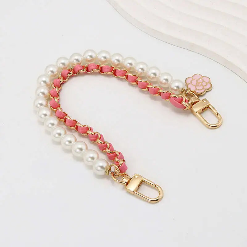 Pearl and pink chain strap with gold clasp on a white background