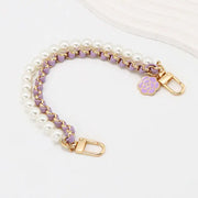 Pearl and purple chain bag strap with gold hardware on a white background