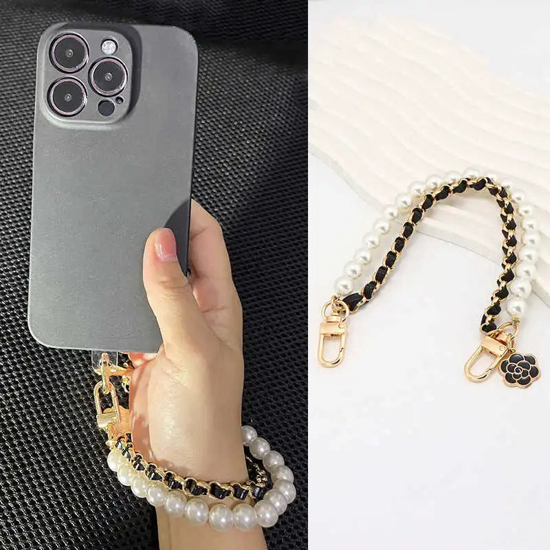 Phone case with pearl strap held by a hand on a black background, pearl strap detail on a white background.