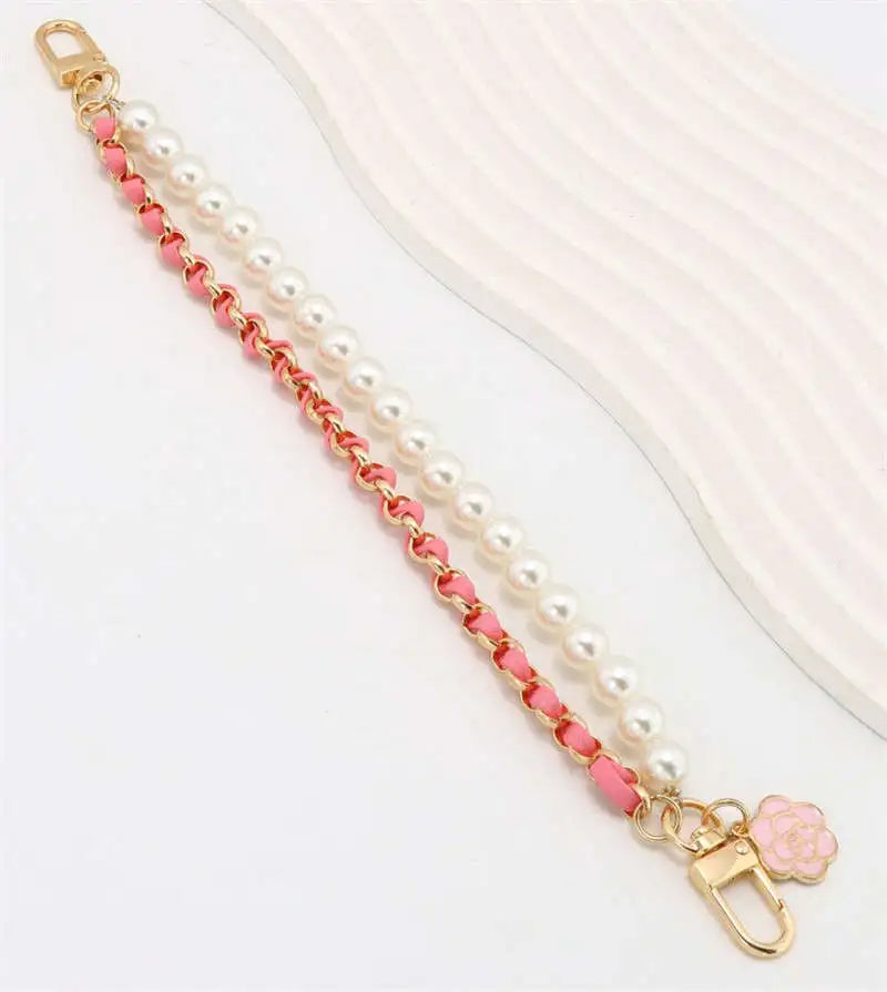 Pearl and pink chain strap with a decorative clasp on a white background