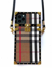 Plaid-patterned phone case with gold accents and strap on a white background