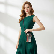 Woman in a green dress holding a handbag with a blurred background