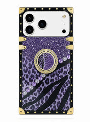 A protective phone case with a purple leopard print and zebra stripe pattern, featuring a central circular mirror, purple rhinestones, and a black border with gold-tone metal studs and corner protectors.