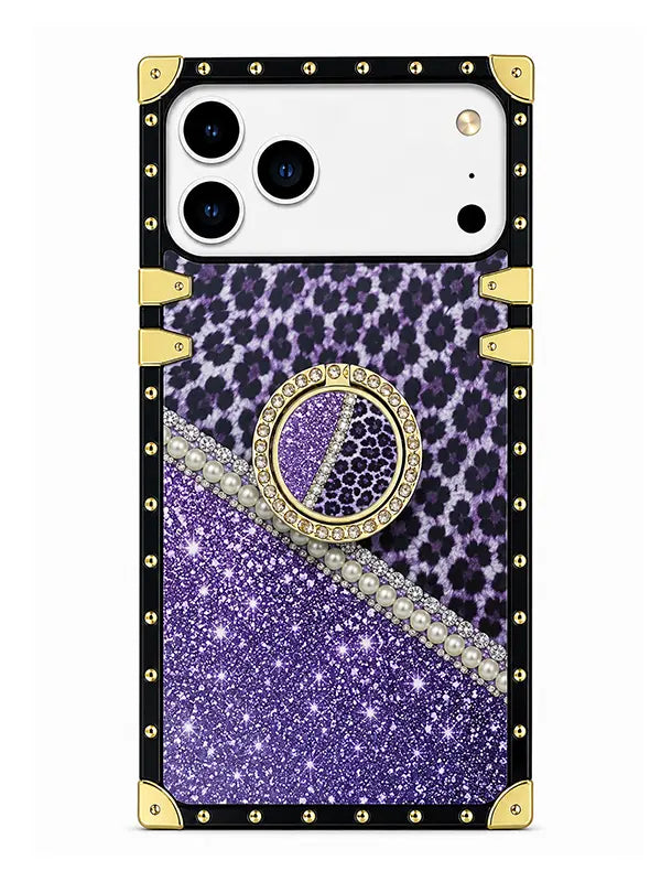 A protective phone case with a black border studded with gold rivets, featuring a split design of purple leopard print and purple glitter, with a rhinestone-embellished circular ring holder in the center.