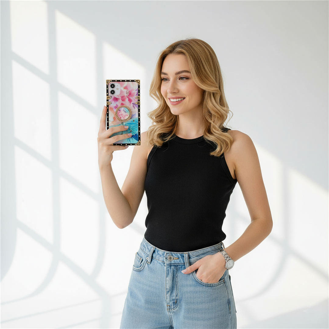 Woman holding a phone with a colorful case against a bright background