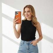 a woman is holding a phone in orange square phone case with heart-shaped ring holder