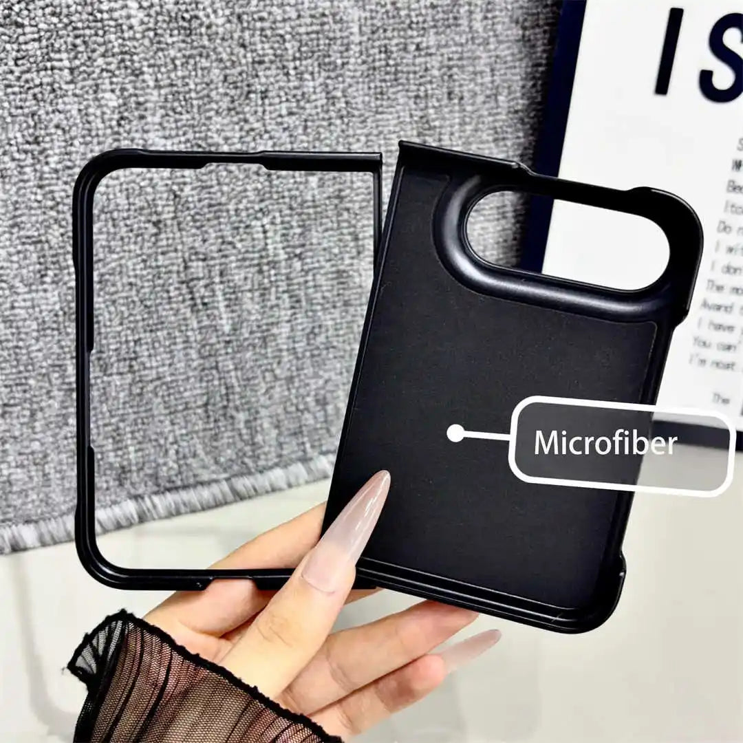 A hand holds a black phone case with a large camera cutout and a second matching black frame piece beside it. The case has a microfiber texture, and a label reads 'Microfiber.